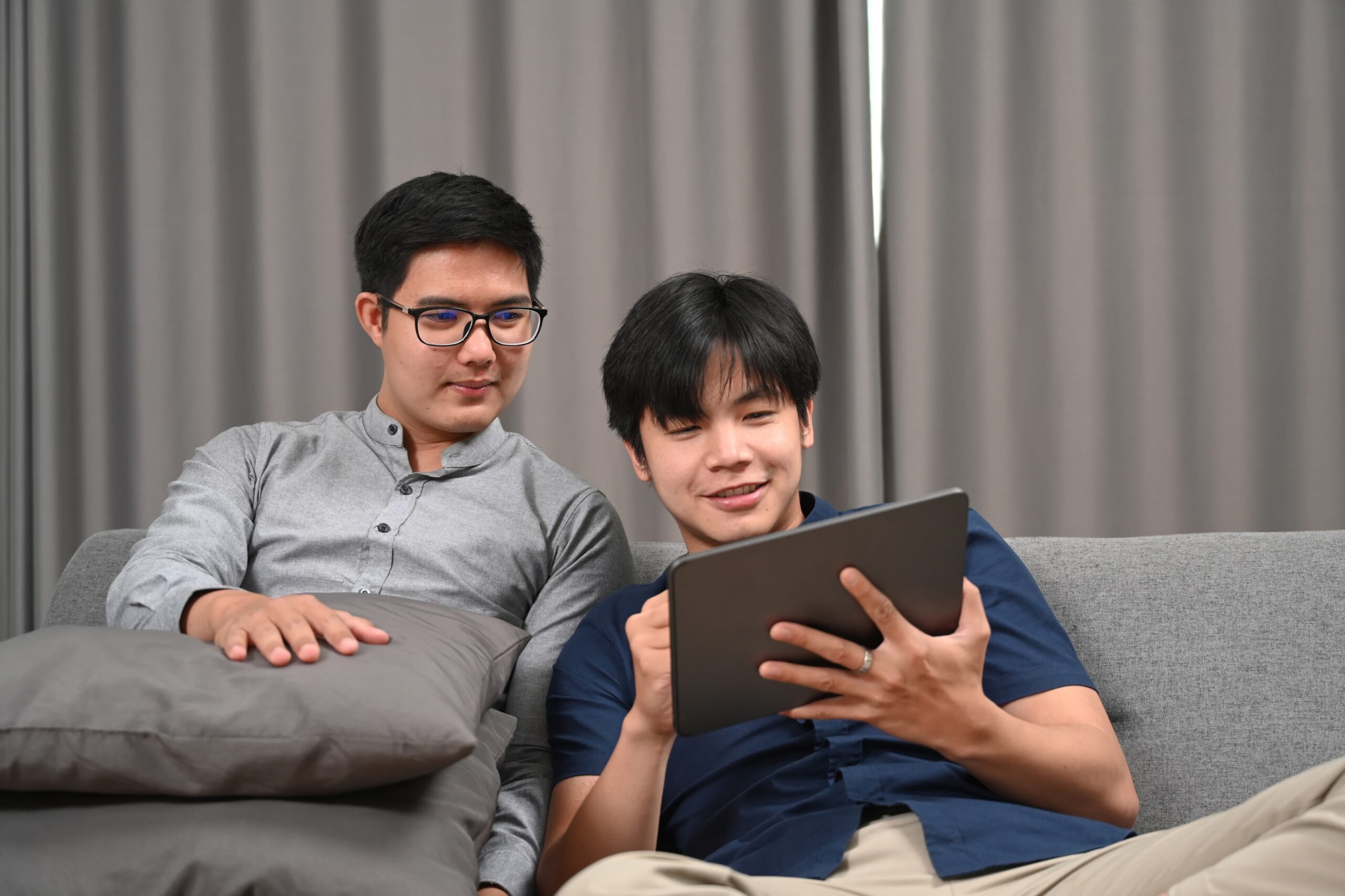 Gay couple improving communication skills during online couples counseling session in the comfort of their Brooklyn apartment.