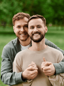 Two men in emotional conversation during online gay couples therapy session addressing infidelity, trust rebuilding, and relationship healing with a compassionate NYC therapist
